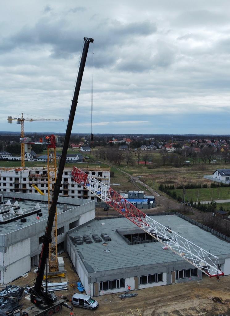 Widok z góry na plac budowy z żurawiem wieżowym i dźwigiem samojezdnym